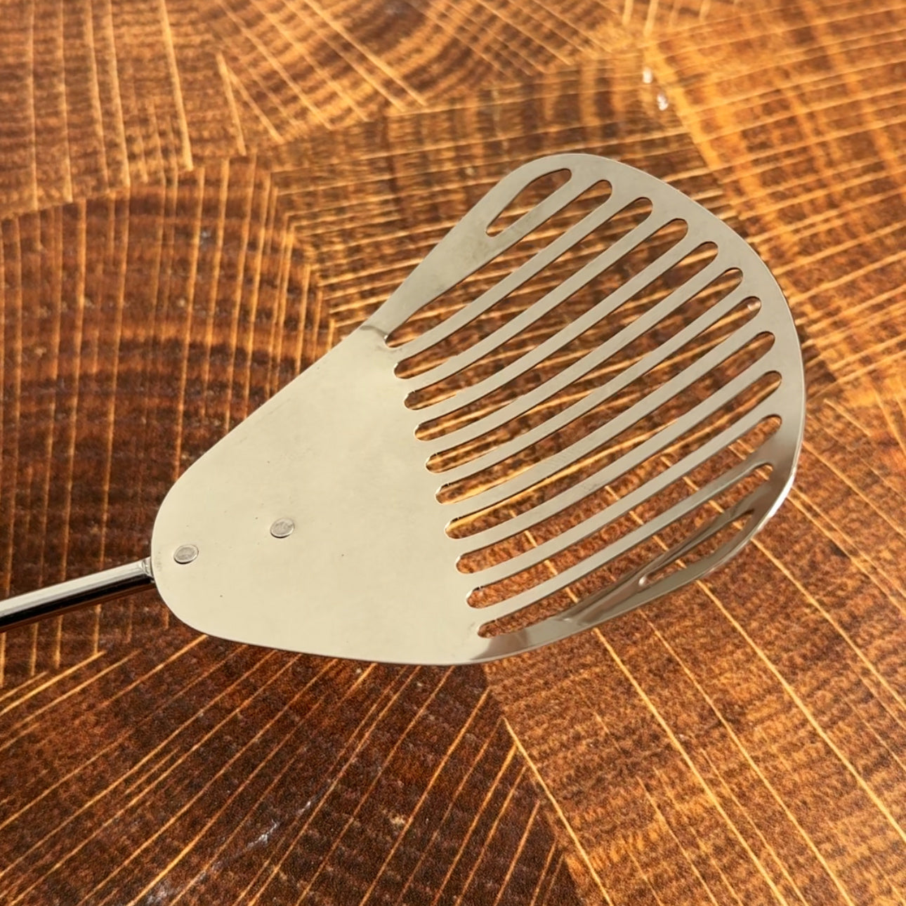 Metallic spatula on a wooden surface